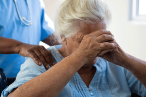 nurse-consoling-senior-woman-at-nursing-home