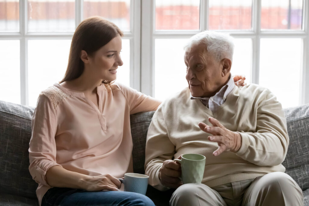 Caregiver helping senior with memory loss during mealtime at home
