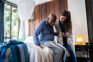 caregiver-helping-elderly-senior-black-man-at-home